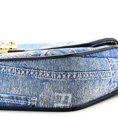 Blue denim baguette bag close-up of black-trimmed edge and patchwork stitching