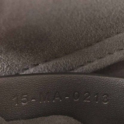 Leather serial stamp on handbag lining with raised numbers and letters.