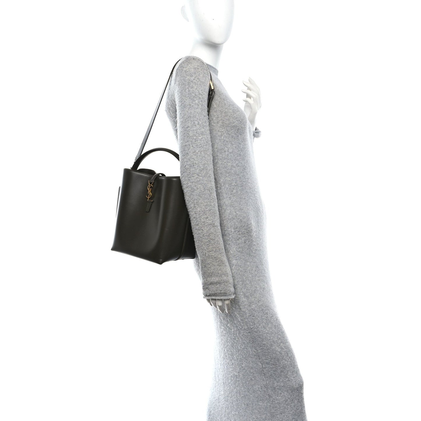 Shiny bucket bag worn on shoulder strap, dark leather with gold zipper pulls.