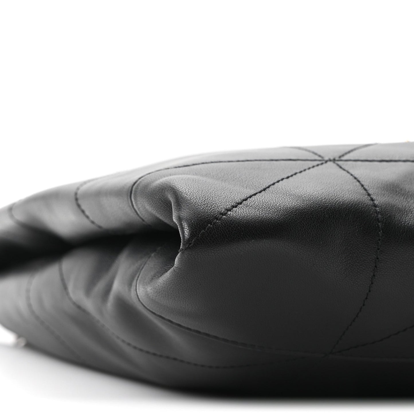 Black quilted leather bag side with stitched diamond panels