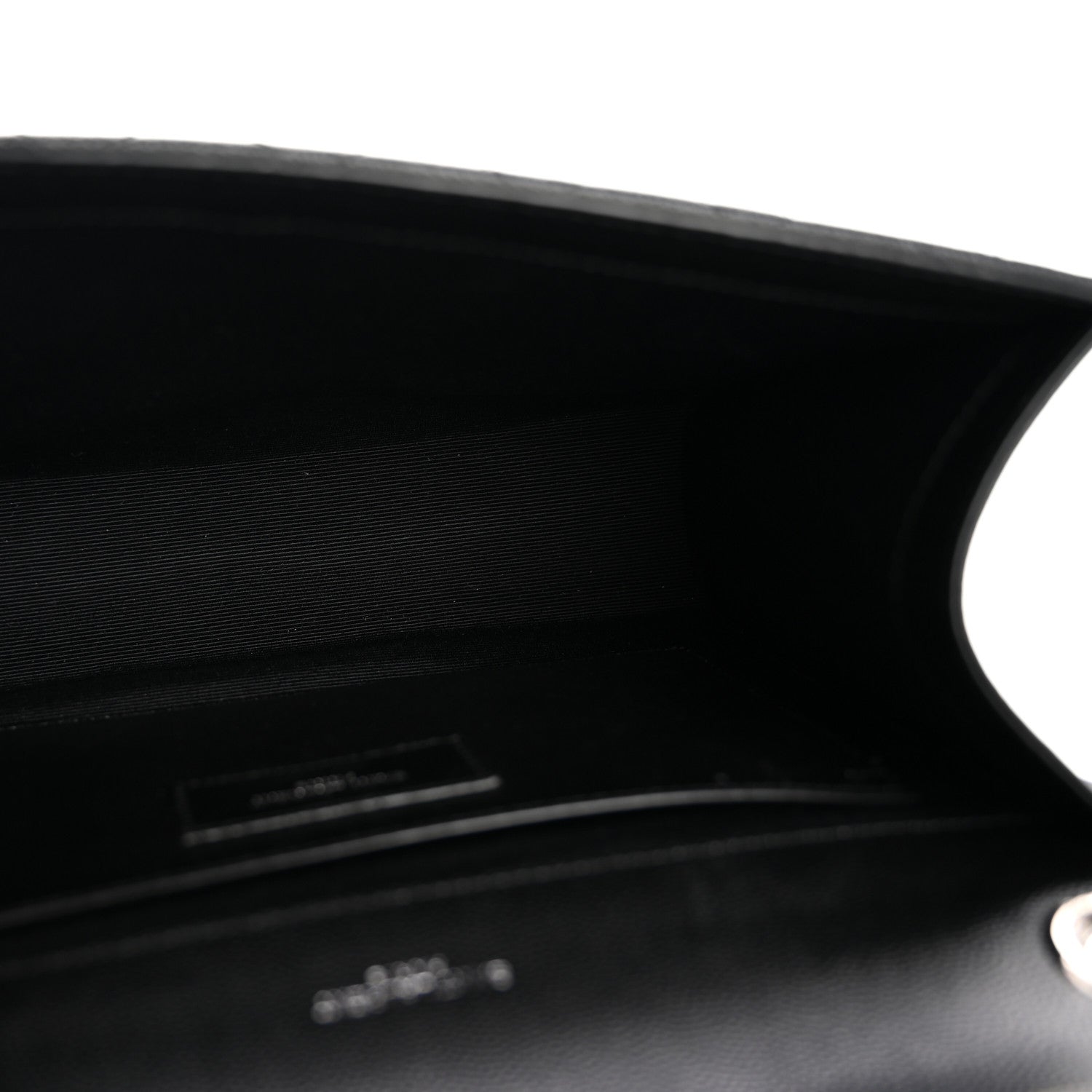 Black satchel interior opening with stitched edge and small logo plaque