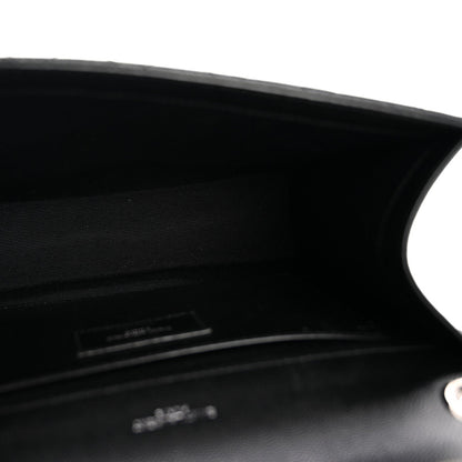 Black satchel interior opening with stitched edge and small logo plaque