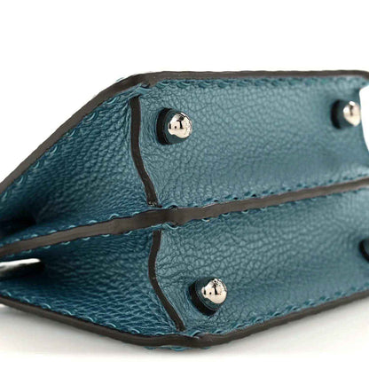 Blue leather satchel interior with snap buttons and stitched edge detail.