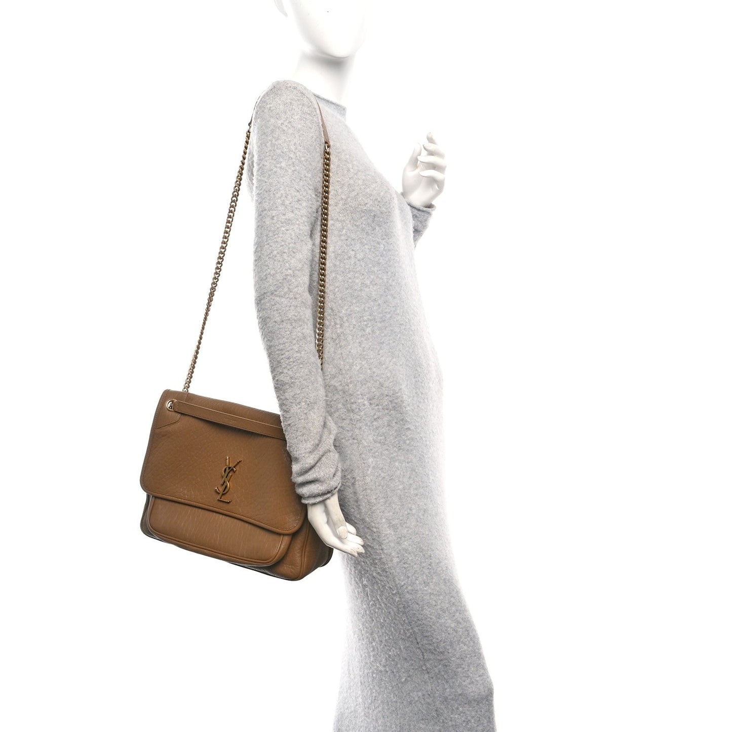 Small chain crossbody satchel held by model, grained dark cork leather.