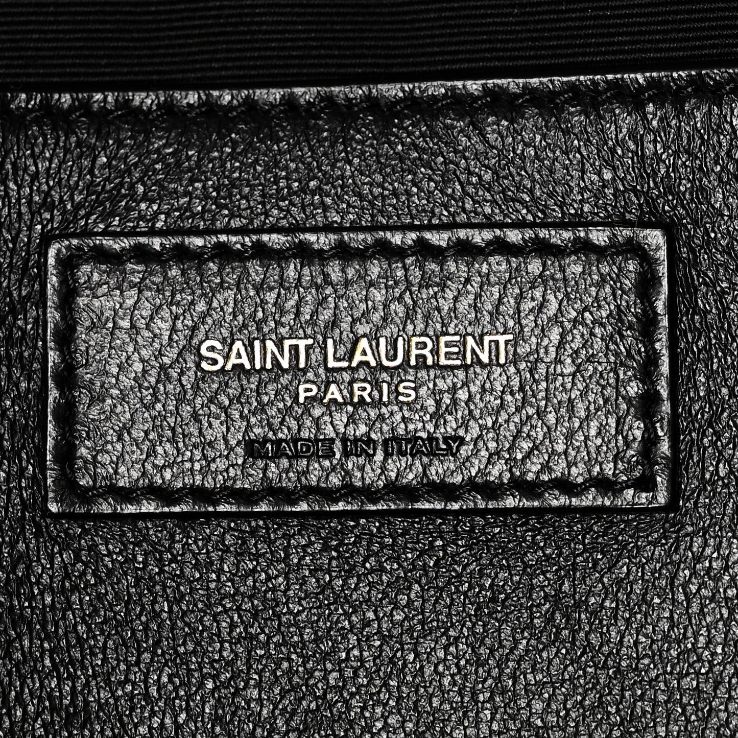 Black leather brand label reading SAINT LAURENT PARIS and MADE IN ITALY