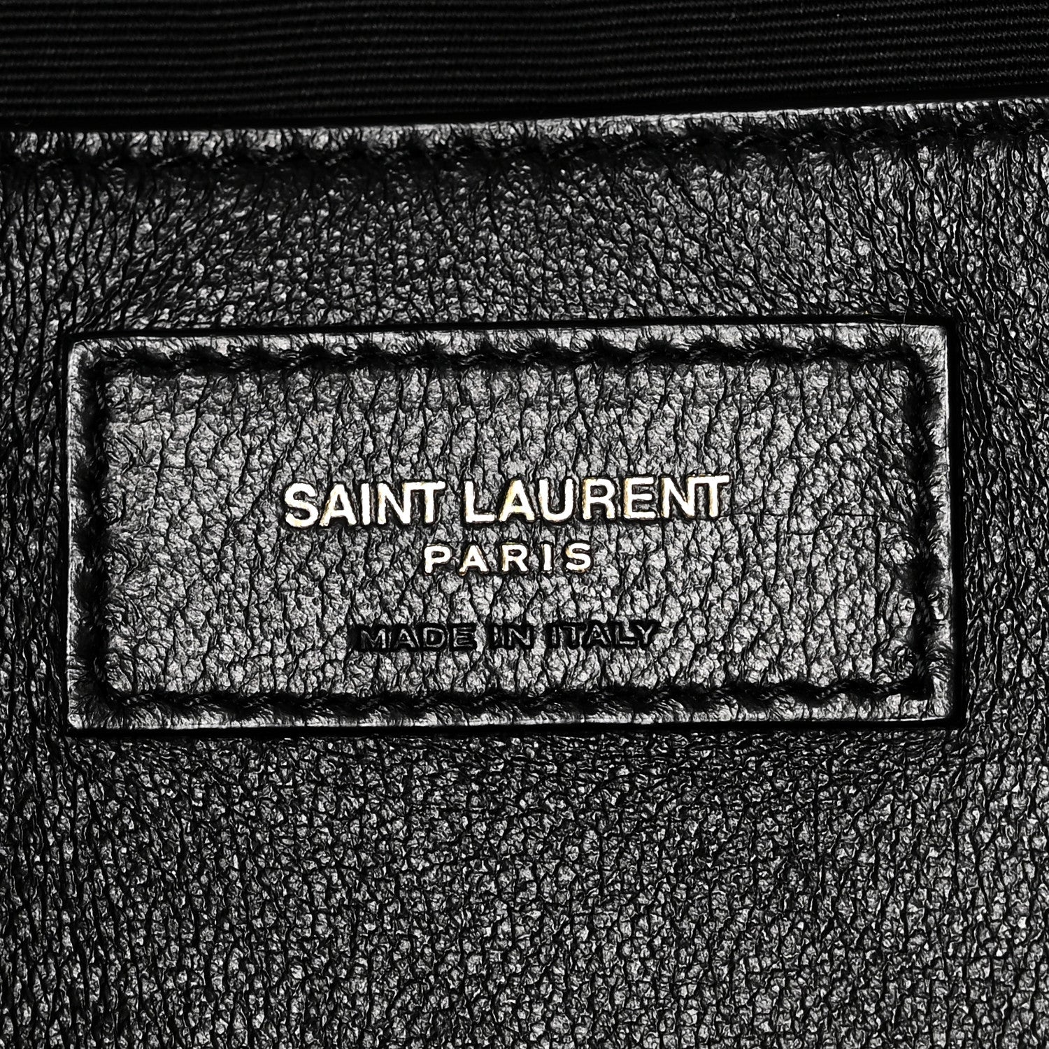 Black leather brand label reading SAINT LAURENT PARIS and MADE IN ITALY
