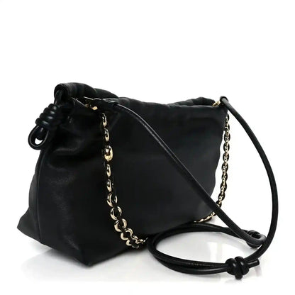 Black leather clutch with chain strap and long leather shoulder strap, side view.