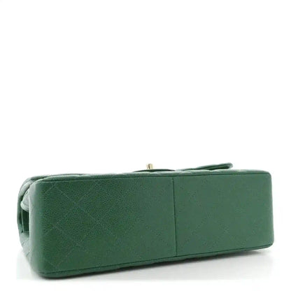 Green quilted leather bag underside with top handle and structured base.