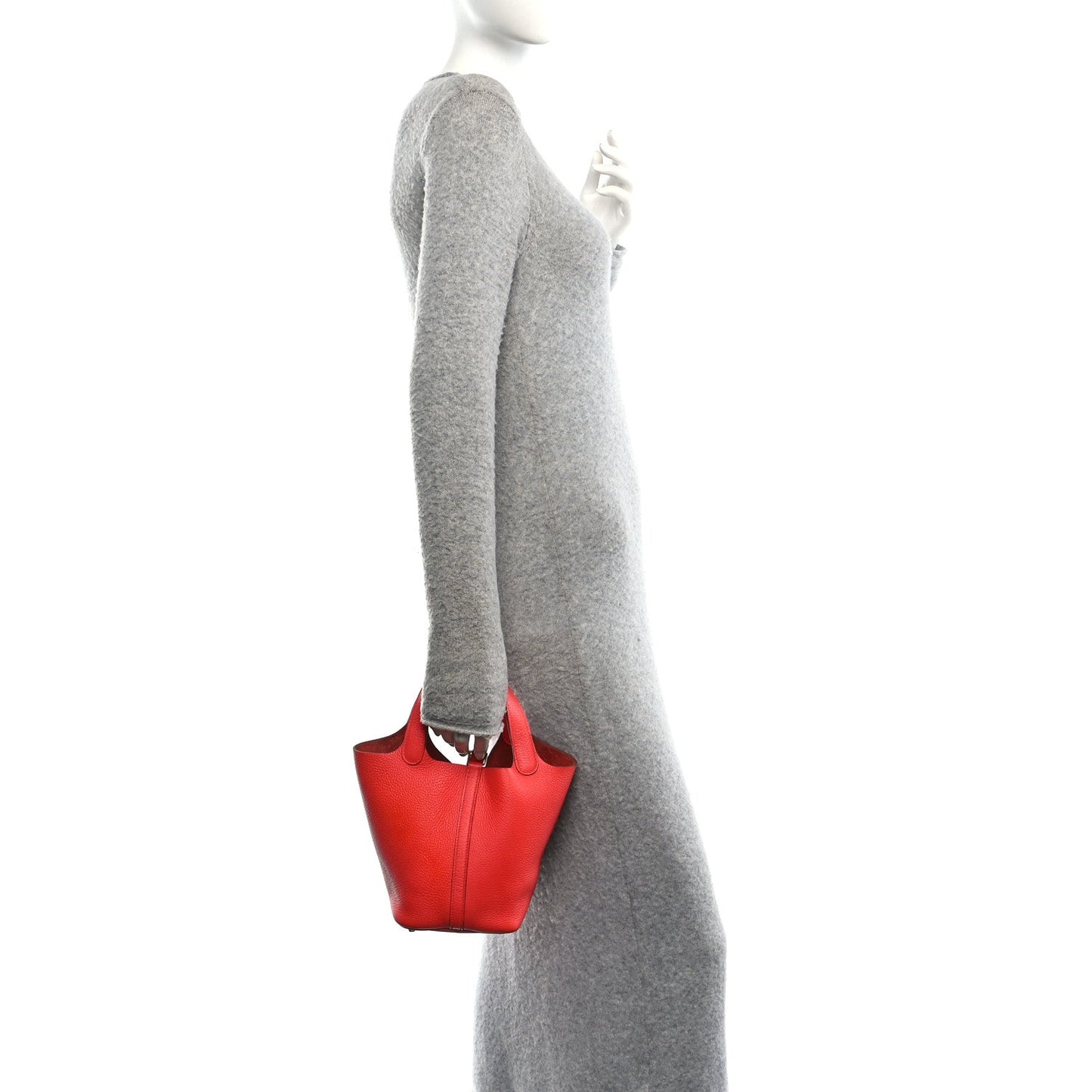 Red leather tote bag worn at the side with long sleeves, side view