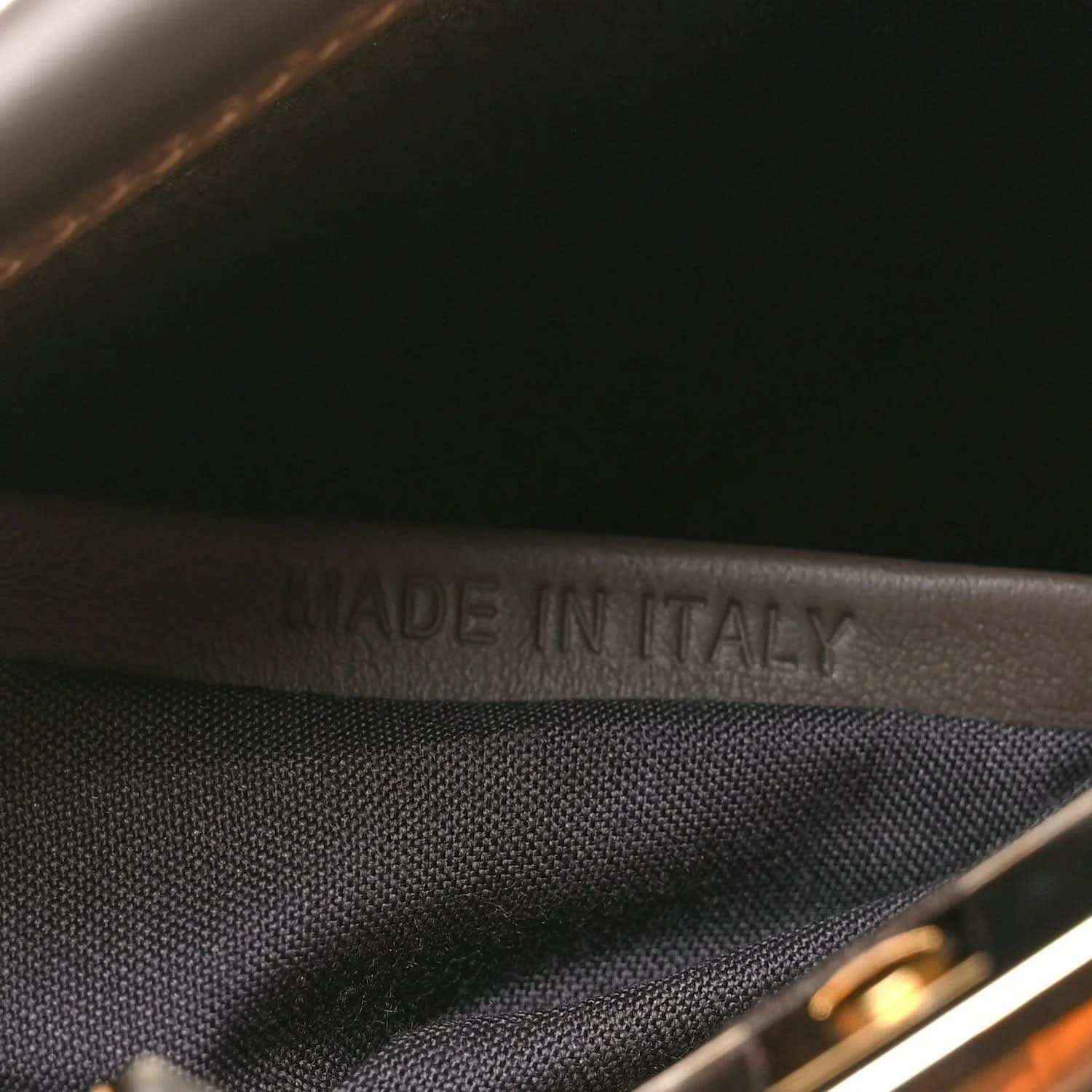 Made in Italy stamp on dark fabric lining inside the satchel.