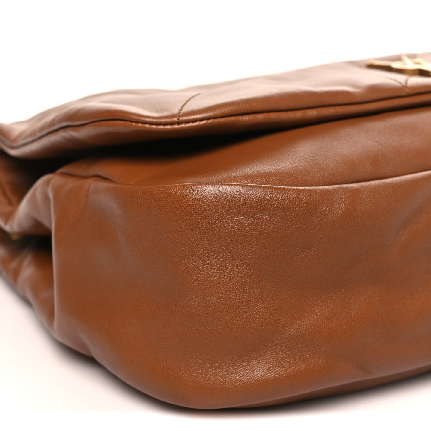 Tan-brown leather shoulder bag side, showing fine grain texture and stitched seams.