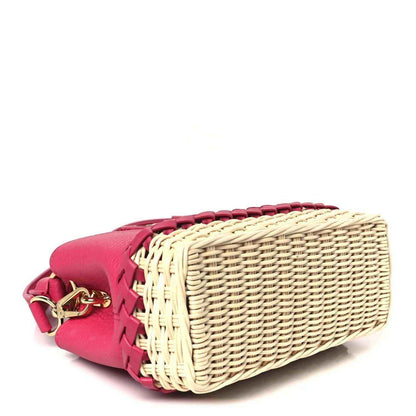 Magenta mini handbag with woven rattan body and pink leather trim, side view