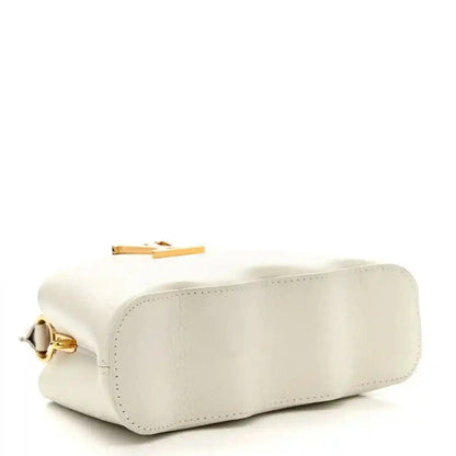 Louis Vuitton Capucines mini handbag, white, side profile with gold turn-lock