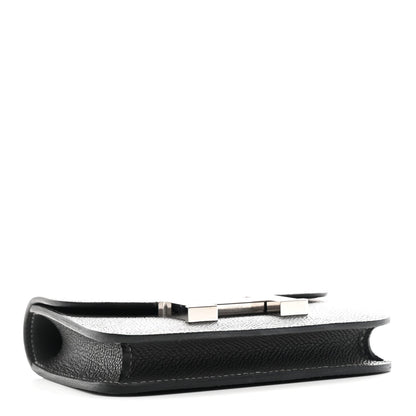 Constance slim wallet profile view in dark textured leather with H clasp hardware