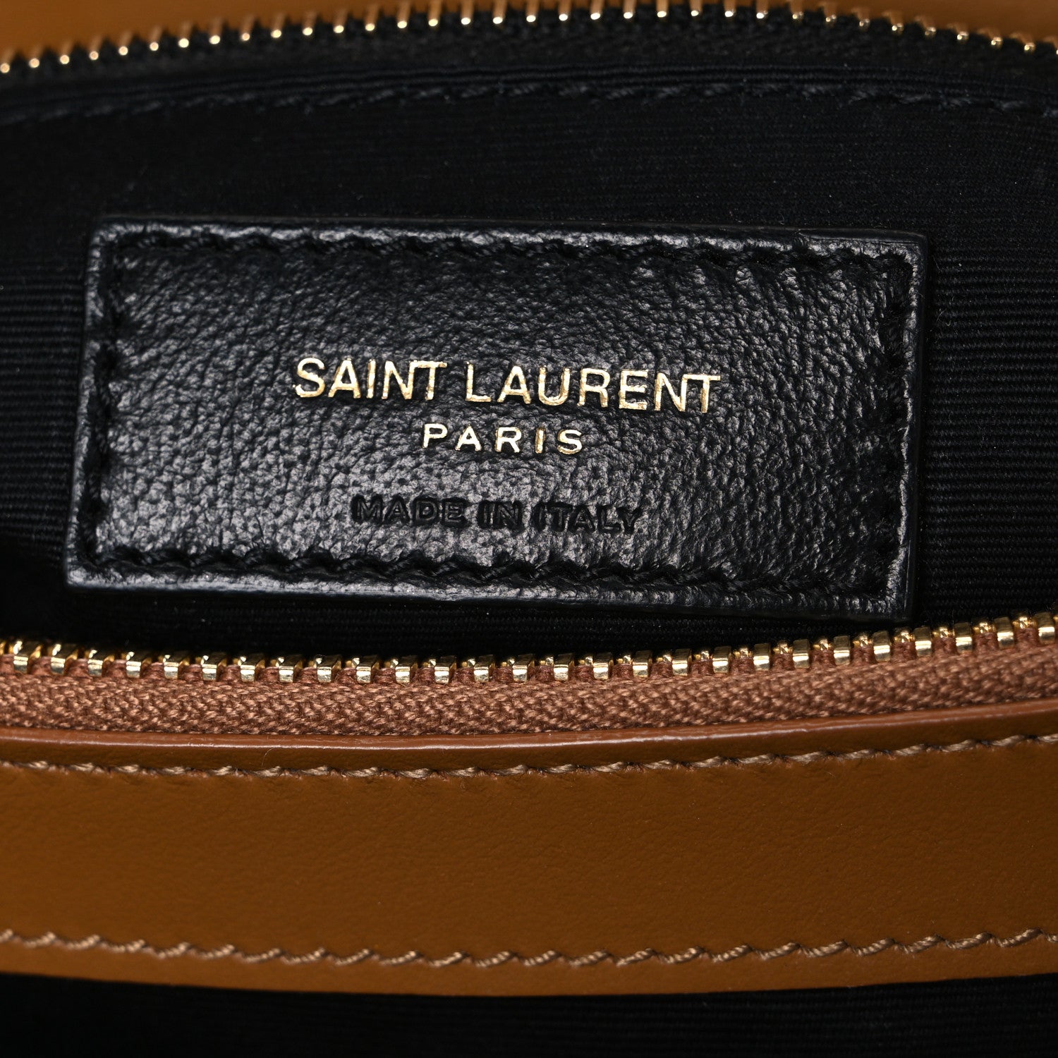 Black leather brand label on satchel interior, with SAINT LAURENT PARIS and MADE IN ITALY
