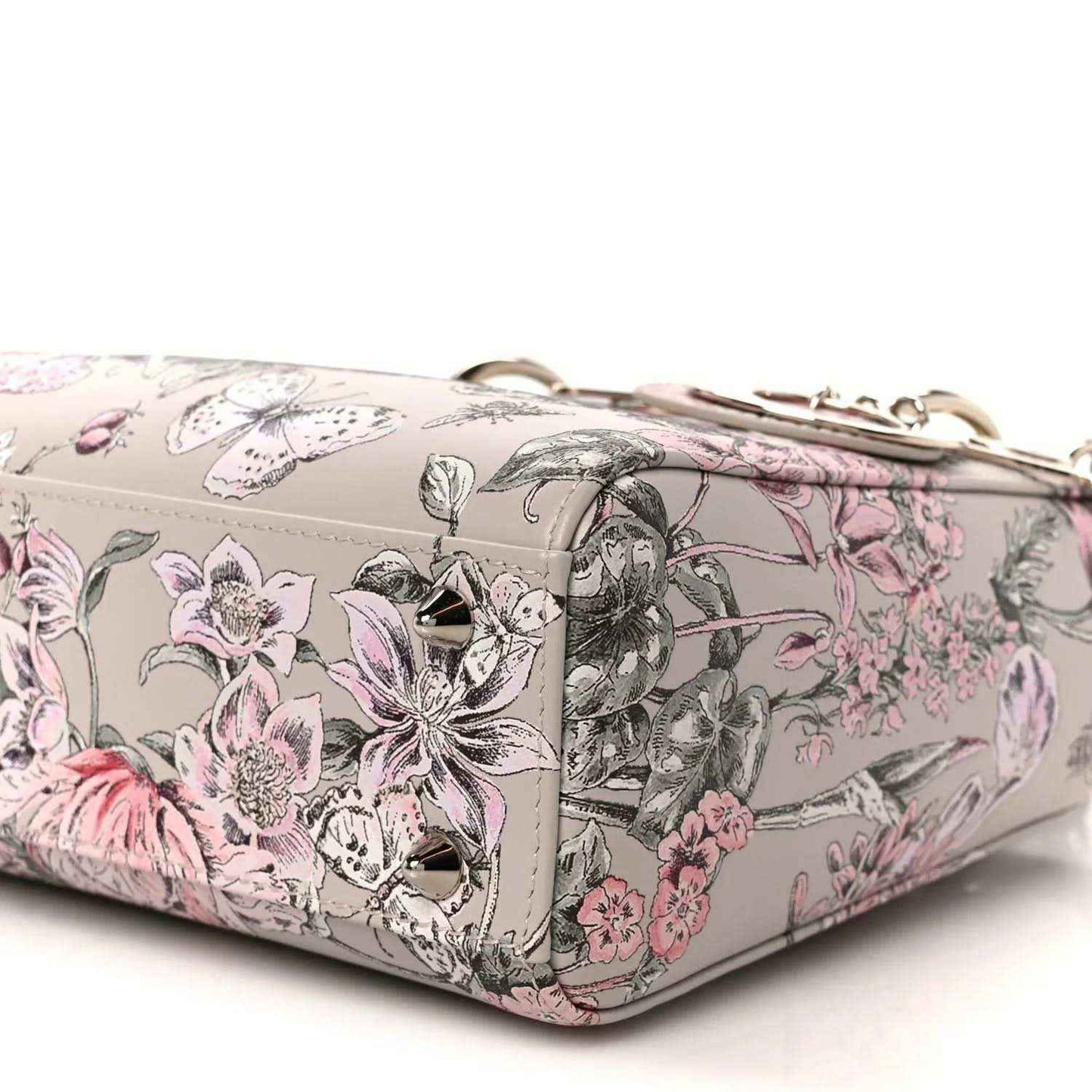 Small Lady Dior handbag side view with pink floral print, strap and metal clasp