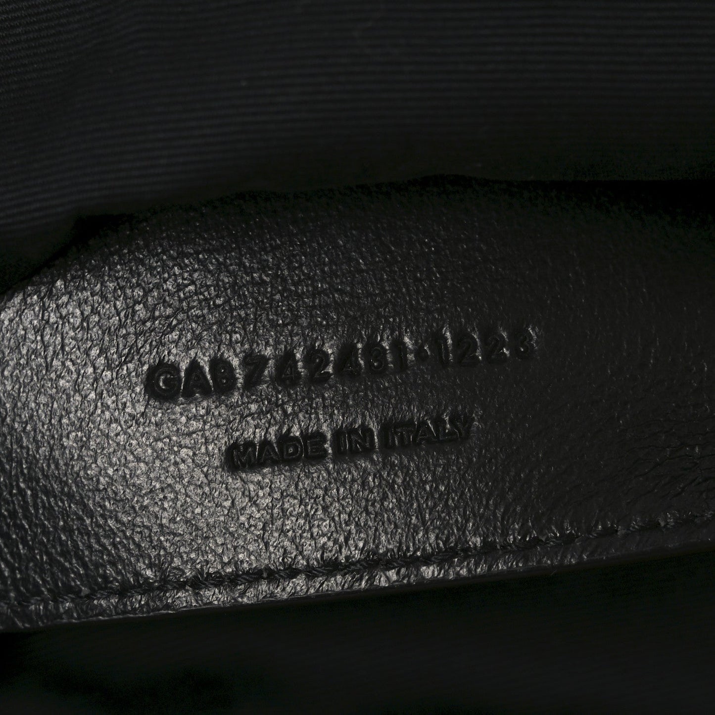 Embossed text on black leather interior of shoulder bag, includes MADE in Italy