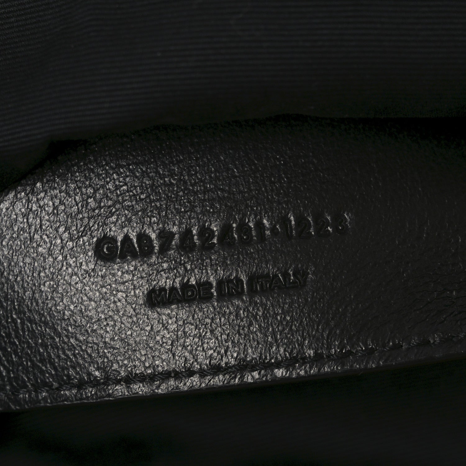 Embossed text on black leather interior of shoulder bag, includes MADE in Italy