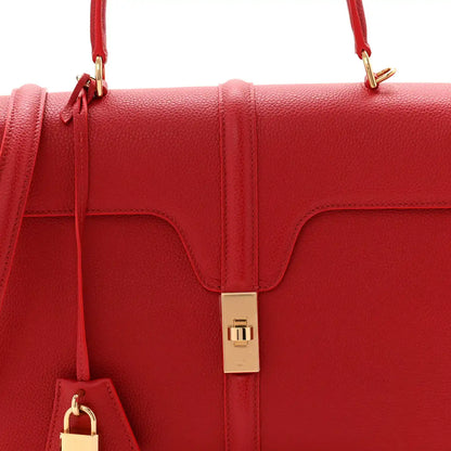 Red grained leather flap top with gold clasp and side pull tab
