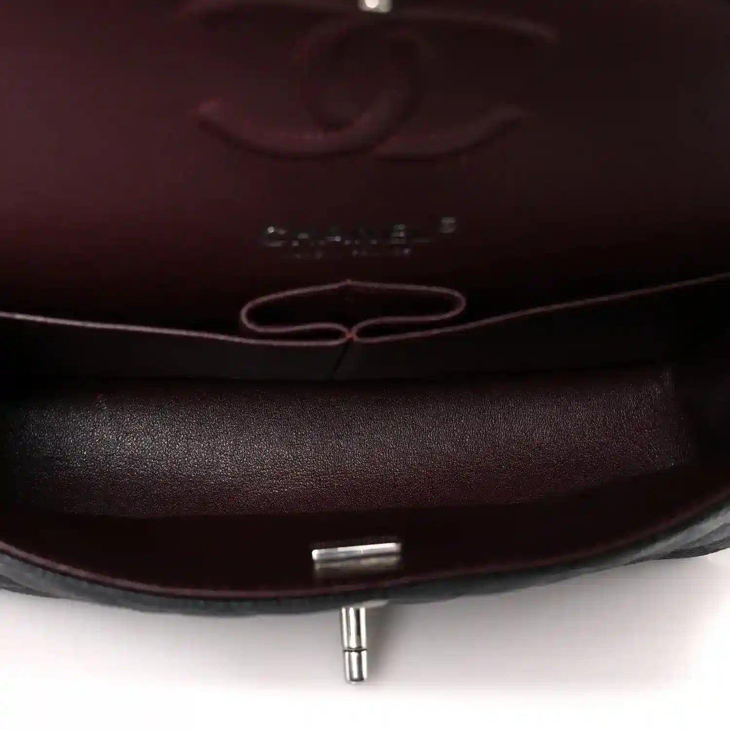Flap bag interior lining with metal turn-lock post and stitched edges