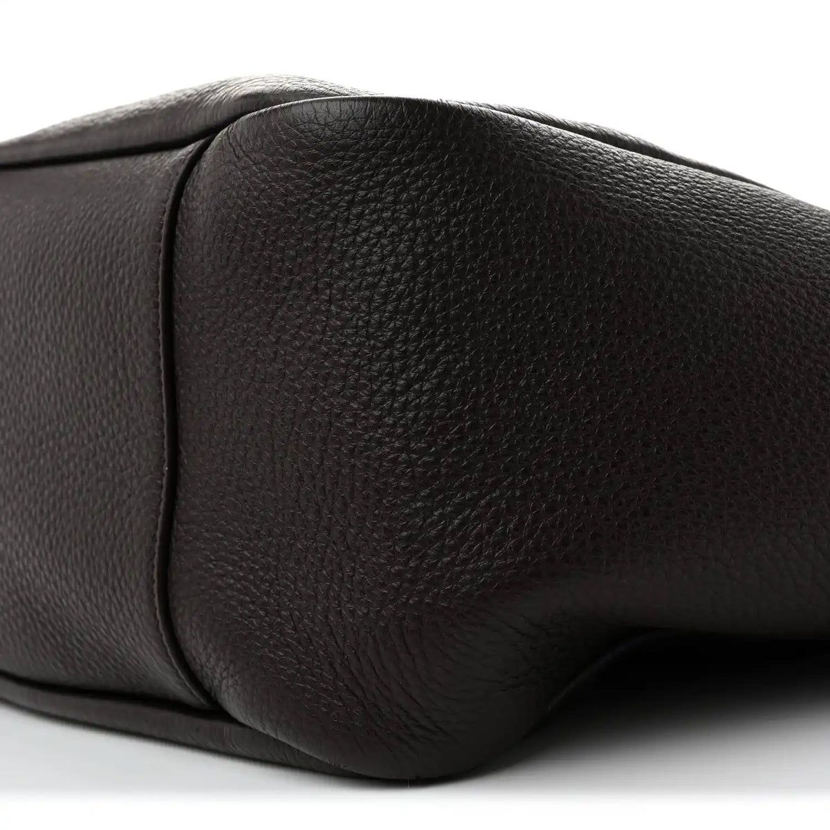 Grained leather Bea tote side panel detail with curved corner seam, dark tone