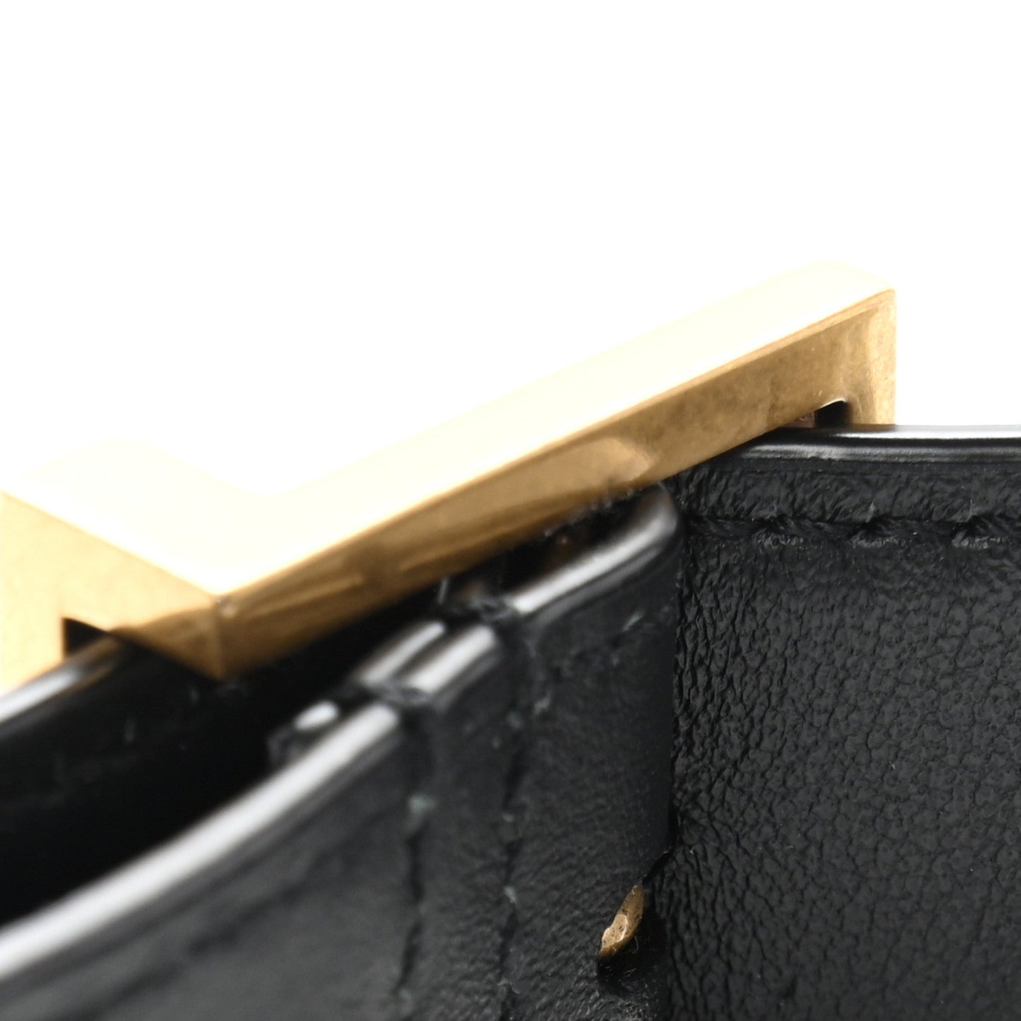 Small black leather hobo bag corner with brass-toned tab detail