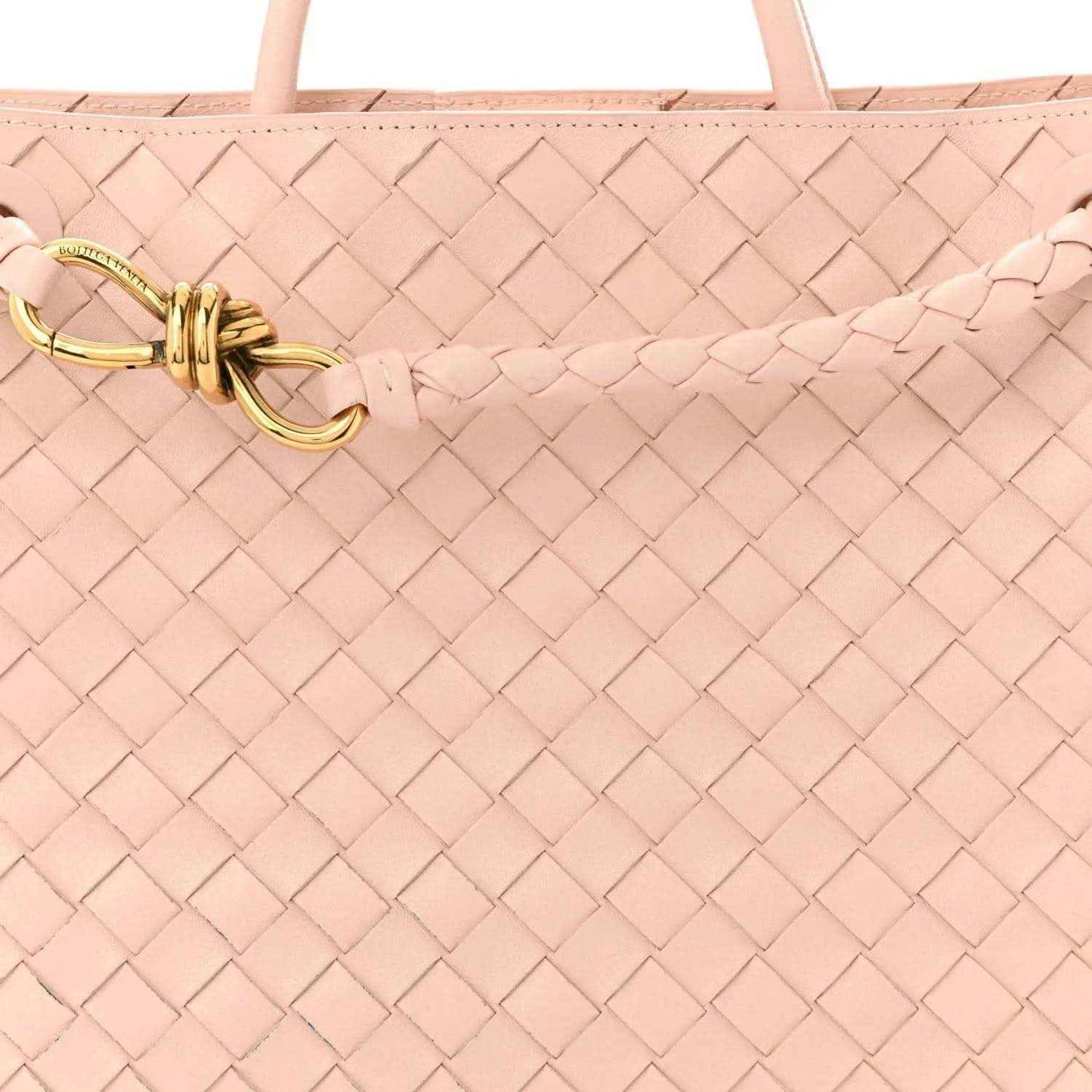 Pink intrecciato leather bag with gold toggle clasp on braided strap
