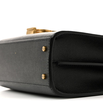 Black leather mini bag corner close-up with gold-tone stud hardware.