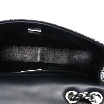 Black small flap bag interior with satin lining and metal frame opening