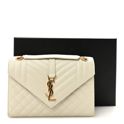 Cream quilted satchel with front monogram latch and gold chain shoulder strap