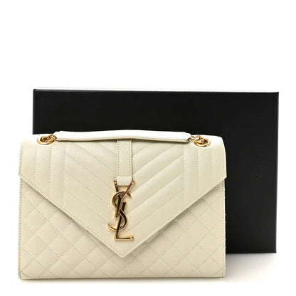 Cream quilted satchel with front monogram latch and gold chain shoulder strap