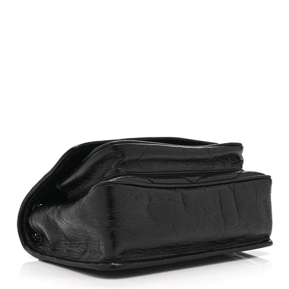 Black leather satchel bag with crinkled texture and folded top flap