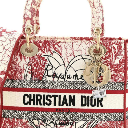 Embroidered canvas tote with Christian Dior logo stripe, red-and-white hearts, gold charms.