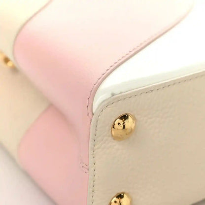 Cream leather handbag corner with gold snap button and blush pink edge panel