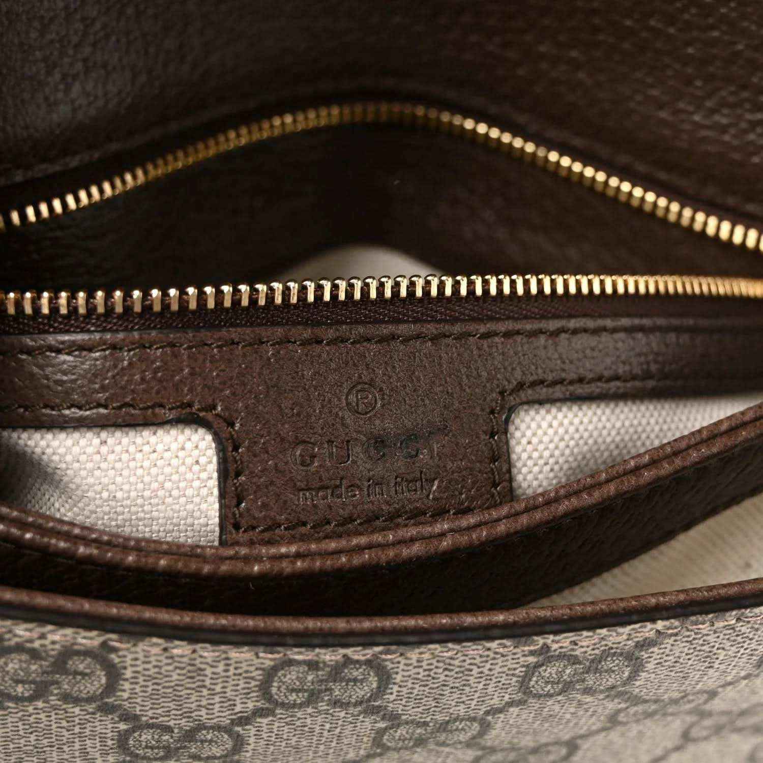 Interior zip lining with printed label and gold zipper on GG Supreme shoulder bag