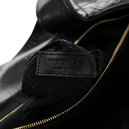 Close-up of black leather zipper lining with small interior brand label