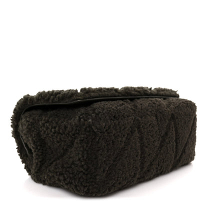 Dark shearling shoulder bag with curved leather top handle, back/side view