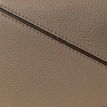 Small Puzzle bag exterior seam and grained leather edge in sand tone