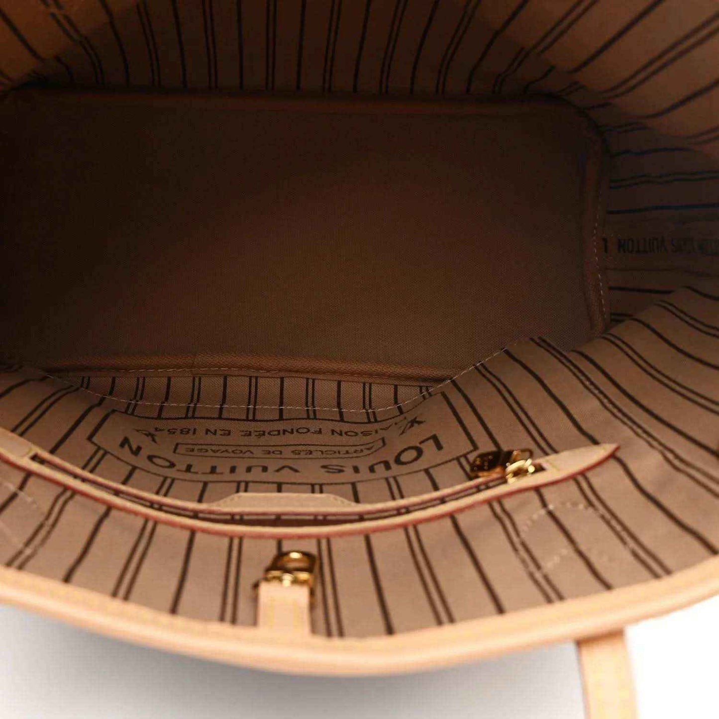 Tote interior close-up showing striped lining, logo print, and zipper with tan trim