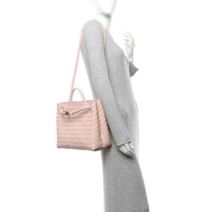 Pink intrecciato leather medium shoulder bag with top handles and gold clasp, side view