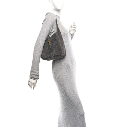 Grey suede hobo bag with top handle and YSL logo front, worn on shoulder