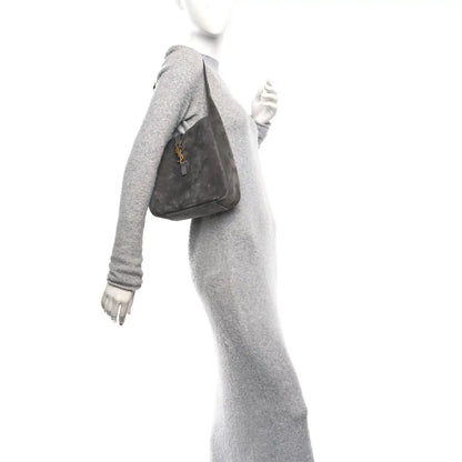 Grey suede hobo bag with top handle and YSL logo front, worn on shoulder