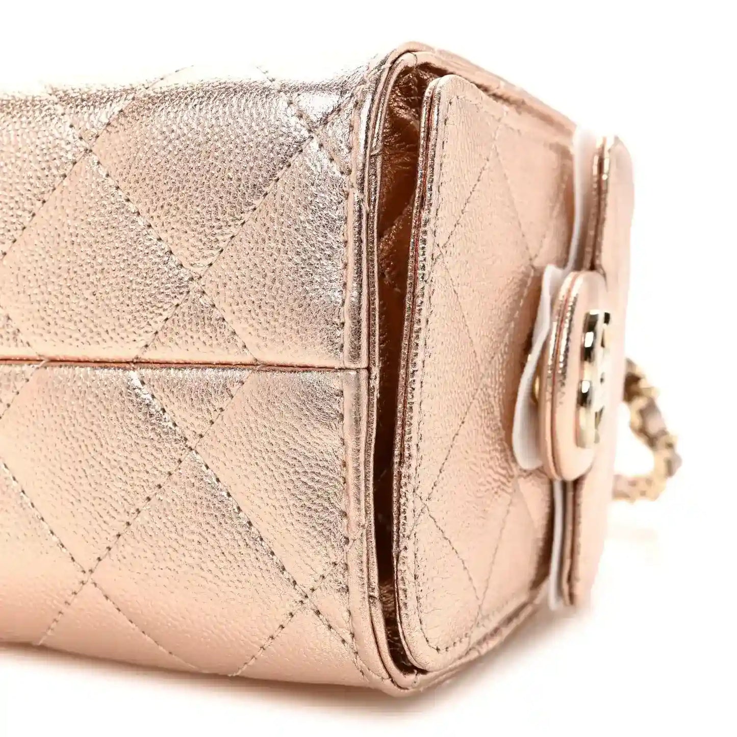 Copper quilted mini handbag side with flap edge, turn-lock clasp, and chain strap.