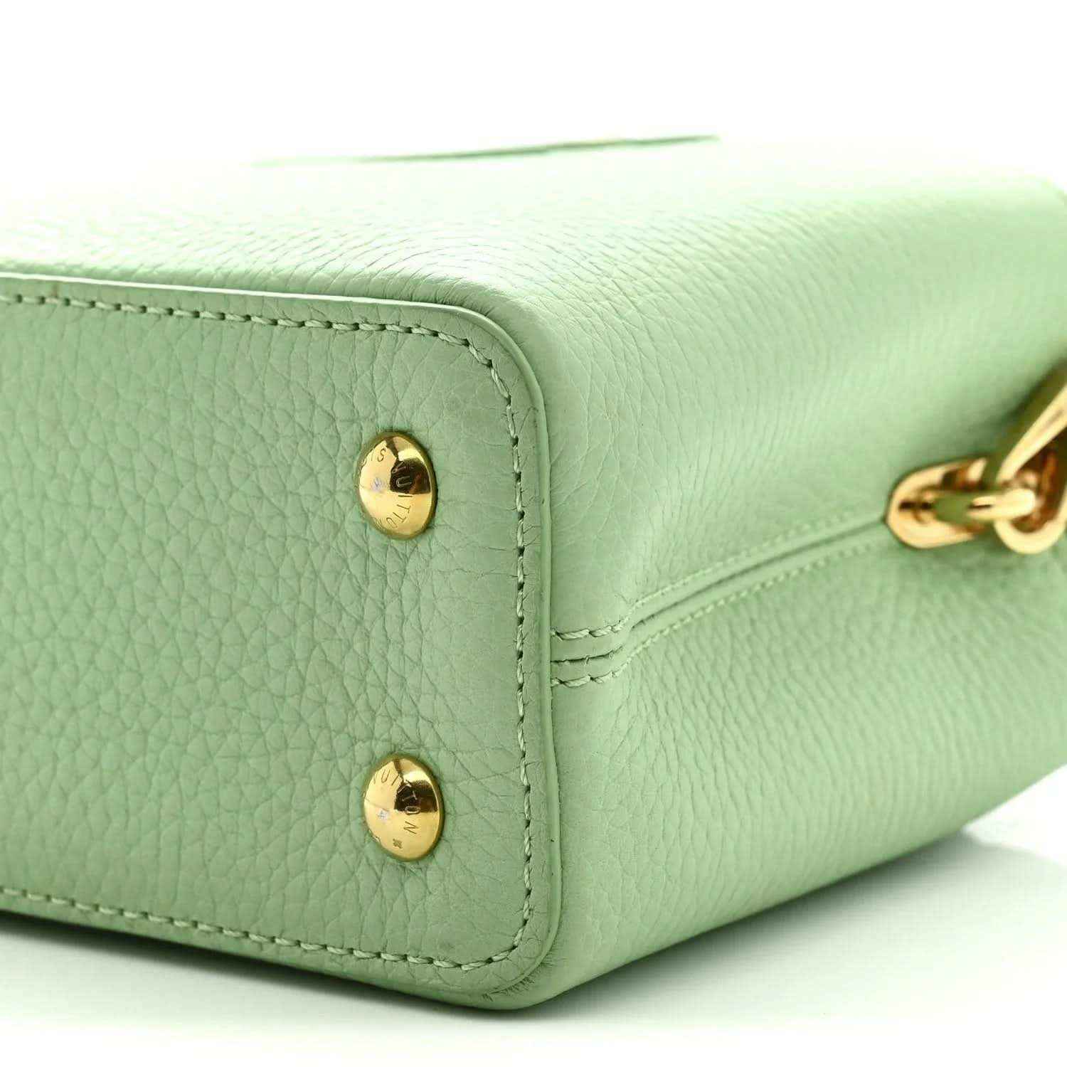 Louis Vuitton mini Capucines leather handbag, vert pomme green, close-up of corner and gold feet