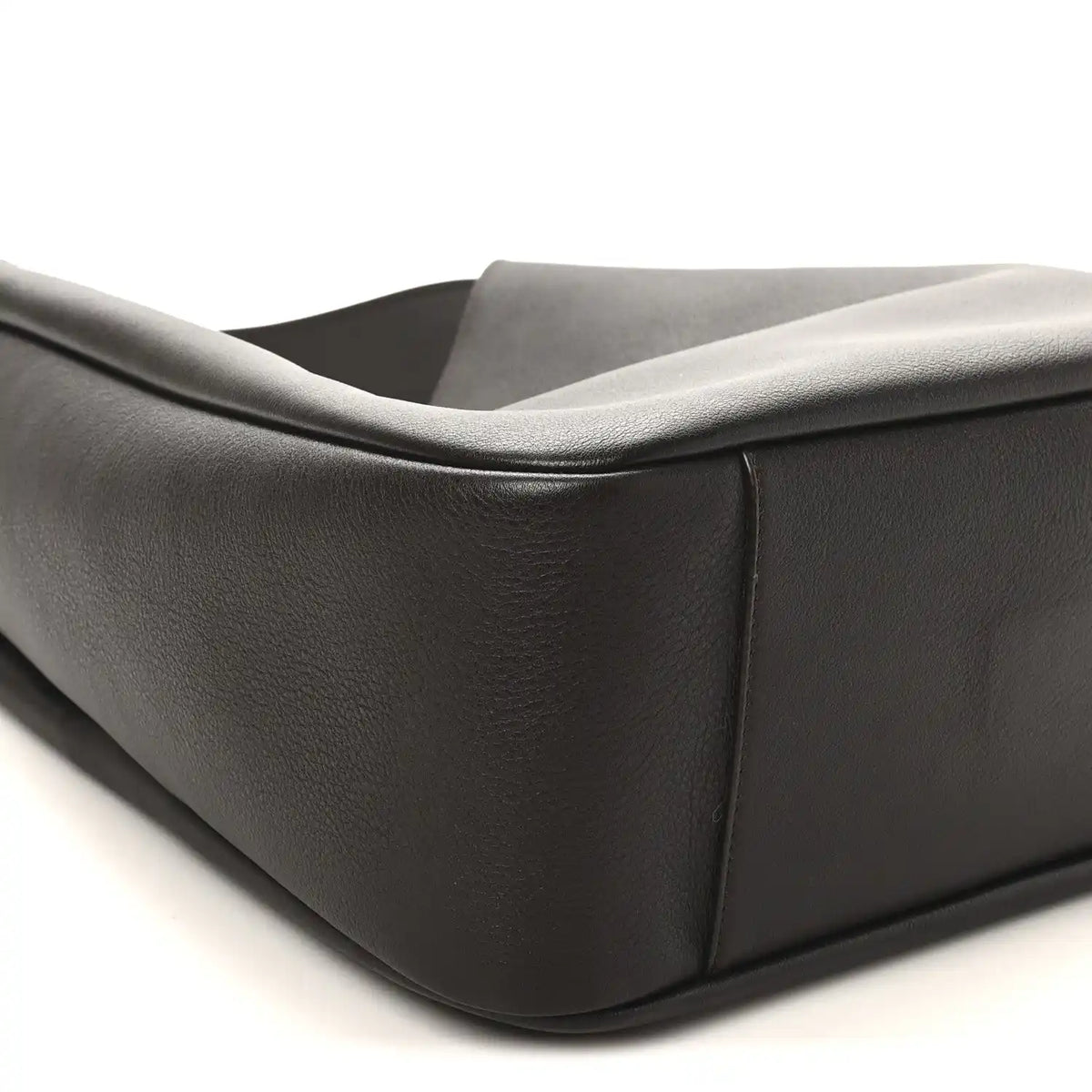 Curved side panel of dark leather hobo bag with folded top edge