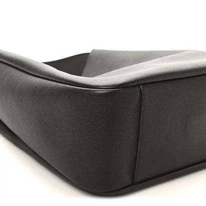 Curved side panel of dark leather hobo bag with folded top edge