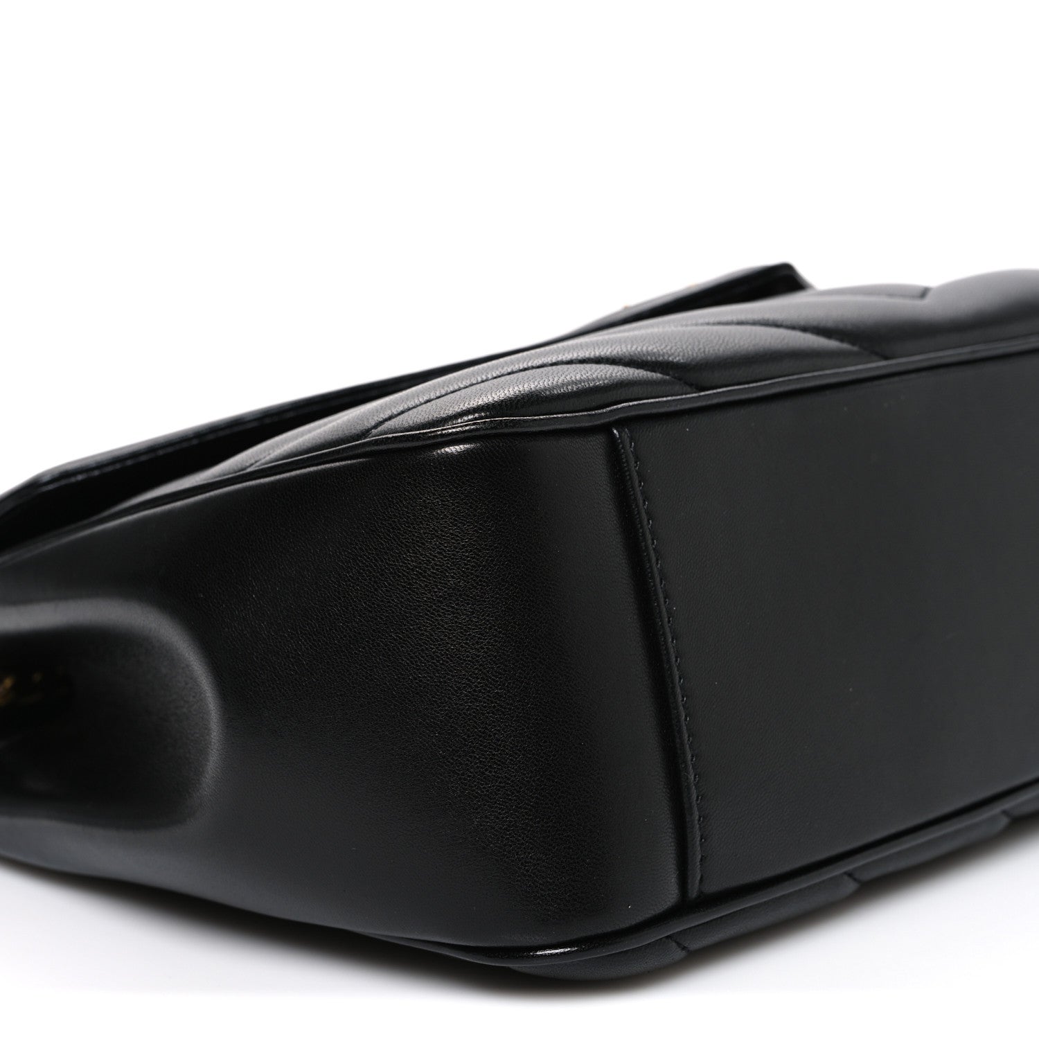 Black leather shoulder bag end panel with smooth edge and subtle grain texture