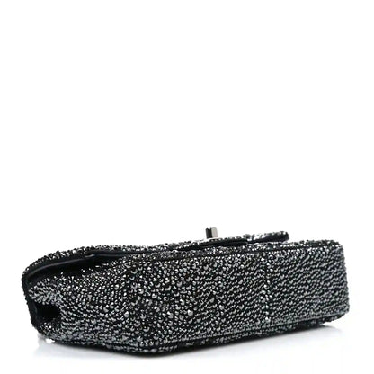 Black rhinestone small flap bag side view with top clasp bar and handle