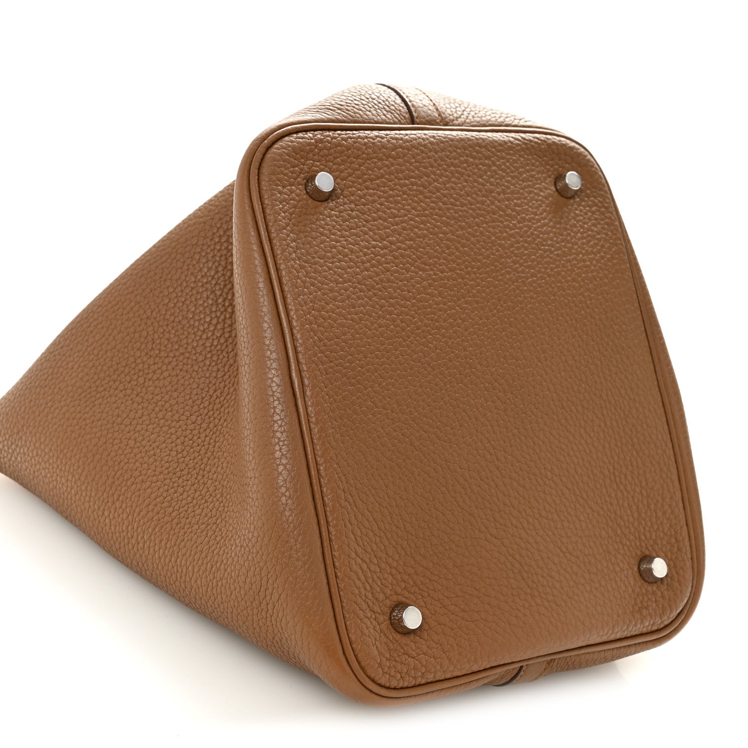 Tan leather tote top corner close-up with metal studs and curved shape