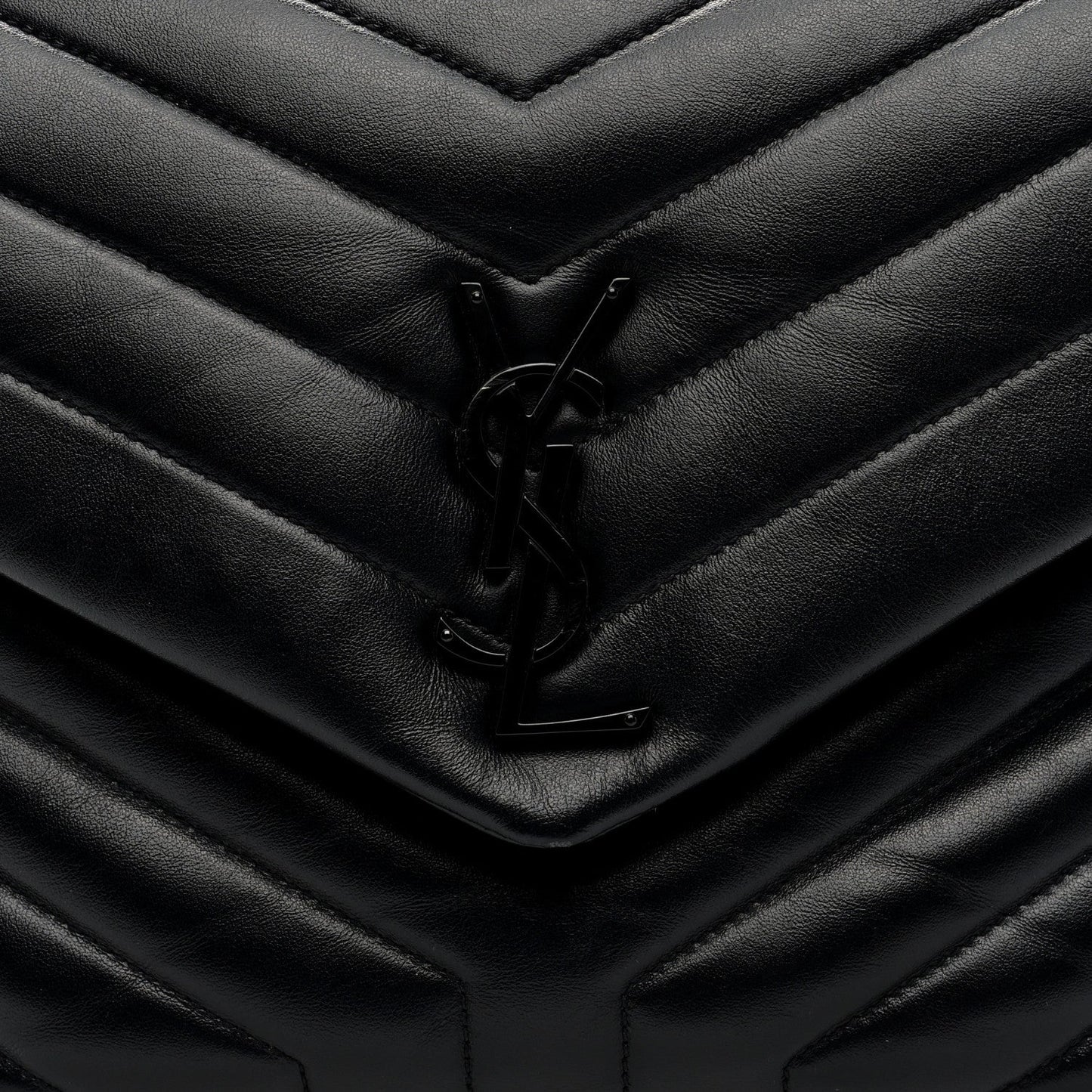 Black quilted satchel front flap with YSL logo clasp detail